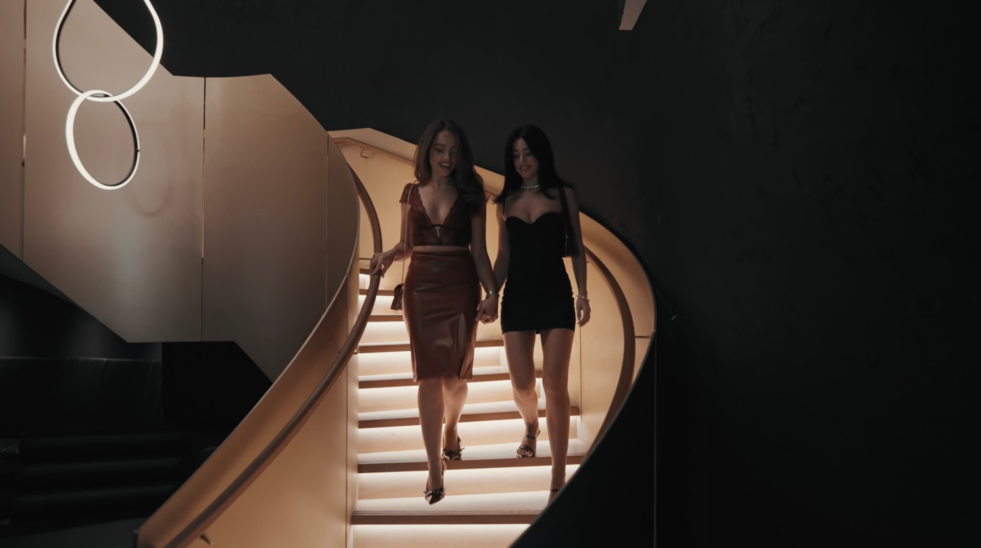 A still from the Cultxre cinematic brand film — two guests descending the staircase at 77 London